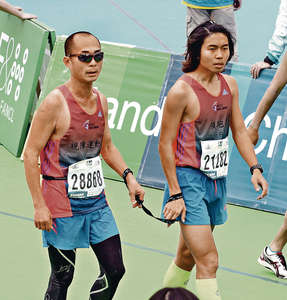 　視障選手梁小偉（左）在「80後」領跑員楊肇麟（右）帶領下以3小時 13分完成賽事。