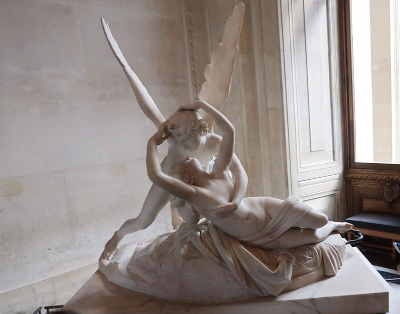 　懂不懂藝術都會給這漂亮的雕塑吸引，原來是18世紀威尼斯名雕塑家卡洛瓦Canova「愛神吻醒賽姬Psyche Revived by Love's Kiss」雕像。<br /><br />原來也有故事在其中：<br />　在羅馬人的想像中，人死去的時候，靈魂是要從唇間飛走的，正是化作蝴蝶的樣子，這飛去的蝴蝶，名字叫做賽姬，乃是希臘神話中的小愛神厄洛斯(羅馬同位體的小丘比特)的妻子。<br /> <br />　在羅馬詩人阿普萊奧斯的《金驢》裏面寫到，賽姬本是一個凡人的女兒，因為美貌可以和愛與美女神阿弗羅狄特（羅馬神話中與之對應的女神是維納斯）媲美而受到嫉妒，阿弗羅狄特派她的兒子厄洛斯去懲罰她，沒想到厄洛斯卻被她的美貌俘獲，成了她的丈夫，但是厄洛斯卻不讓她看到自己的容貌。後來賽姬禁不住兩個姐姐的慫恿，晚上趁厄洛斯熟睡之時，在油燈下偷看他的樣子，驚異於小愛神的俊美而失手滴下一滴燈油，燙醒了厄洛斯，因為誓言遭到背叛而憤怒的厄洛斯不再與她相見。<br /><br />　但阿弗羅狄特也仍然心懷嫉妒追著可憐的姑娘不放，她迫使賽姬做了許多不可能完成的苦工…省略一兩百字…。後來賽姬仍然難逃人類的命運，把她引向危險的邊緣的正是人類特有的好奇，她非常想知道究竟什麼東西能夠補償一天的美貌，而她的手裏，只有冥后讓她交給阿弗羅狄特的一個精緻的小盒子，她打開那個盒子，那裏面的睡眠馬上抓住了她，讓她昏迷不醒。賽姬似乎無法消受這種供神使用的睡眠，她瀕臨死亡，渾身冰冷，這時候在天上飛翔的厄洛斯看到了她，正是她臨死的樣子喚起了這個丈夫的同情心，他把睡眠趕走，喚醒了他的妻子，把她帶去見宙斯，要眾神之王承認他們的婚姻。