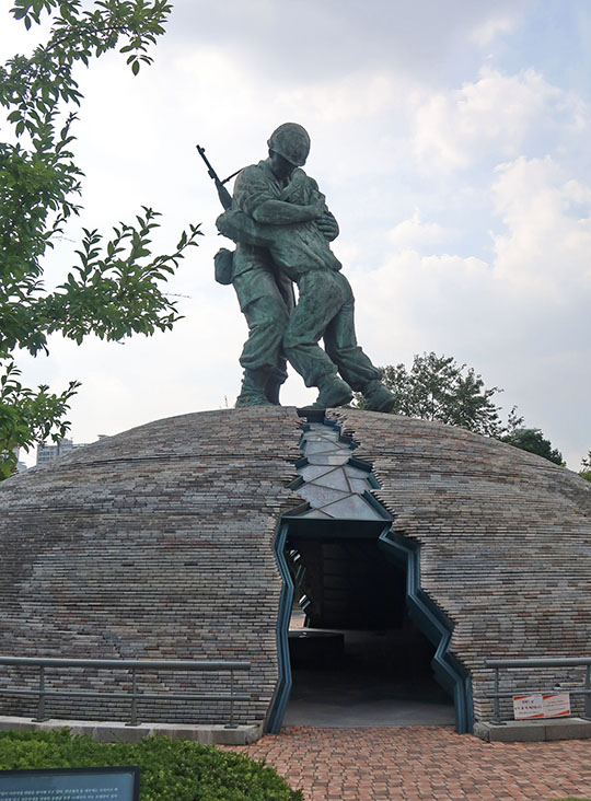 　除了正面的雕塑，停車場出入口也有兩個很有意思的雕塑。<br /><br />　一是「兄弟像」，這是取材於真實故事。韓戰時哥哥為南韓軍官，弟弟為北韓士兵，兩人在戰場重逢相擁而泣；站著的半球上有一道裂縫，代表著分裂的南北韓。雕塑表現了民族和解、團結和統一的願望。