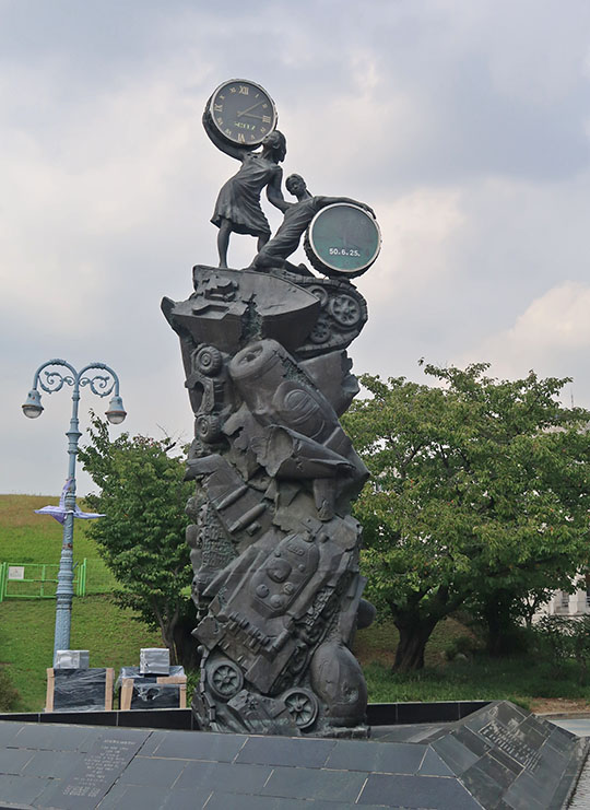 　「和平鐘塔」，下方少女懷抱的鐘表象徵著韓戰爆發的時間，上方少女懷抱的鐘表顯示當前時間，雕塑通過兩名少女形象化地表達了韓國民族渴望統一與祈願和平的鐘塔。