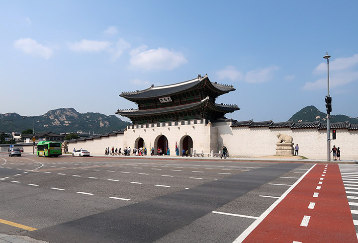 　光化門，是朝鮮王朝正宮景福宮的南門，也是其正門與最大的城門。作為韓國人心目中的“國門”，光化門經歷了多次戰亂，一次遷移，兩度被毀，三度重建。這個看上去新簇簇，其實是重建的，才重新面世了七年。<br /><br />　話說1910朝鮮給日本吞併後，日本準備在當時漢城主要的南北向大街的主軸線上建總督府大樓，而光化門就是當時的主軸線上，因此日本人準備把光化門拆掉。但經過當時熱愛朝鮮古建築的日本學者柳宗悅奔走努力，並寫了《為了朝鮮的文化，絕不能失去》的文章，最後朝鮮總督府同意保留光化門，但是將其移建到景福宮的建春門(東門)的北邊。在韓戰期間，光化門遭到炮擊，門樓被燒毀，石造的城台也彈痕累累。1968年，韓政府重建被破壞的門樓，但受朝鮮總督府大樓影響，光化門只能移回原歷史位置附近。二戰後，韓國獨立，韓國人把這棟朝鮮總督府大樓視為國恥的象徵，並沒有把它當作政府建築使用，而是改為國立中央博物館館舍。然而韓國人還是覺得，這樣一棟建築堂而皇之地矗立在漢城的主軸線上是不可忍受的一件事。經過一番爭論，還是決定拆除，以徹底消除國民心上的陰影。1995年，被韓國總統金泳三正式以「清除日本統治時期象徵」為由拆除。2006年，韓國政府決定拆除新光化門，依據歷史原貌進行重建，修復完成的新光化門在2010年8月15日的韓國光復六十五周年紀念當天揭幕，剛好見證了韓國近百年的巨變。
