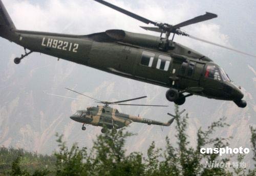 　5月22日，陸航黑鷹和米-17直升機空降帳篷等救災急需物資到受災嚴重的高山羌寨。中新社發 賈國榮 攝