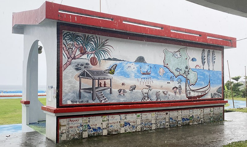 　背後盡是蘭嶼地方特產：林投果，貓頭鷹，拼板舟，涼亭，地下屋，曬飛魚，山羊，海龜…