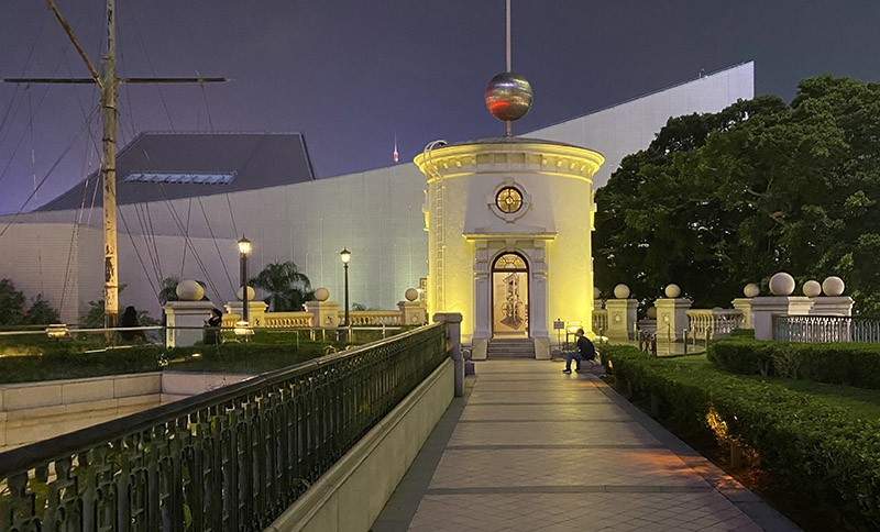 　時間球塔。<br /><br />　在十八世紀時，香港已經是一個繁忙的港口。很多船隻通過蘇彝士運河到達香港後再到中國，而船隻到達香港時已歷經過不同時區，所以需要一個報時服務。故香港政府於1883年於尖沙咀設立天文台，並在1884年在水警總部旁興建時間球塔，為來往香港的船隻提供報時服務。時間球塔選址在此，是因為水警總部坐落在尖沙咀海旁的小山丘上，能有廣闊的視野，在海港內的船隻從遠處都能清楚看見這時間球塔。<br /> <br />　當時每天下午十二時五十分左右水警總部的警官會人手將塔頂的時間球升起至塔頂桅杆的最高點，由香港天文台透過地底的電信線路向時間塔發出信號，準時於下午一時正將時間球降下，作為報時信號。港口的船隻利用時間球降下的時間調校經線儀，用來準確計算出船隻的位置。