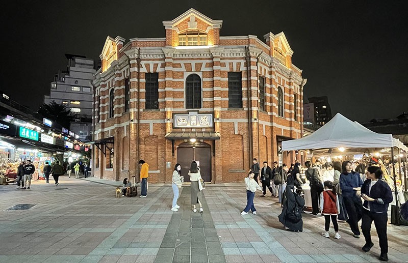 　一路之隔的西門紅樓，建於日治時期，原作為西門市場的室內市集。戰後時期作為演藝場所，今列為臺北市定古蹟，作為文創場所與展演空間。