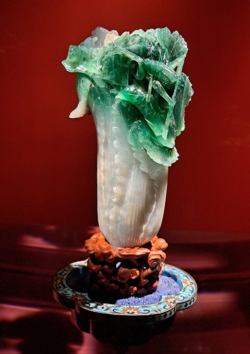 　最後是鎮館之寶「翠玉白菜」，此件玉器的雕刻一體成形，以翠玉自然的色澤刻飾出青綠色菜葉與白色葉柄，象徵女子「身家清白」；而菜葉上停留的兩隻昆蟲是寓意多子多孫的螽斯和蝗蟲。自然色澤、人為形制、象徵意念，三者搭配和諧，遂成就出一件不可多得的珍品。難怪成為故宮最受歡迎的展品，任何時候都人頭湧湧。